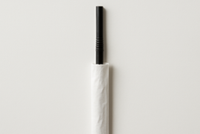 Load image into Gallery viewer, a 7.75" long black straw with a 0.5" flexible neck, in a paper wrapper that has been pushed halfway down the straw to expose 30% of the straw