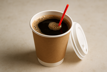 Load image into Gallery viewer, disposable coffee cup with a red coffee stirrer sitting inside the cup of coffee