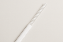 Load image into Gallery viewer, 10.25 clear straw, sticking out halfway out of a white paper wrapper.
